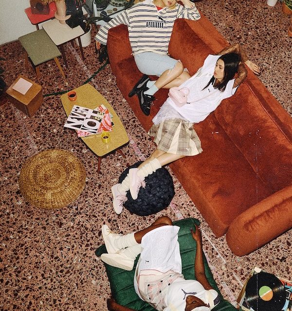 Three models wearing PUMA Suede Bloom campaign looks in a relaxed interior setting, photographed from above.