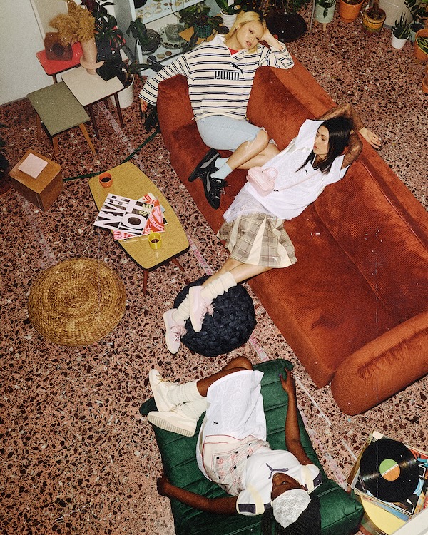 Three models wearing PUMA Suede Bloom campaign looks in a relaxed interior setting, photographed from above.