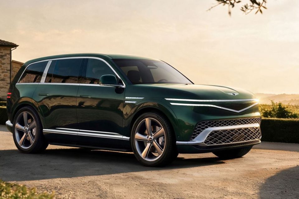Green Genesis GV90 electric flagship SUV in a front three-quarter view on a stone terrace at sunset.