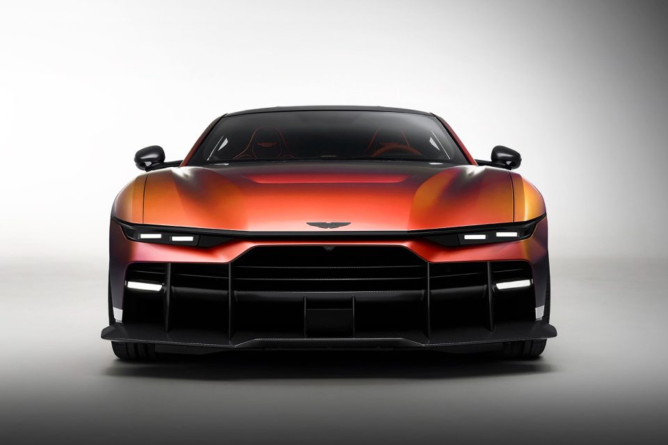 Front view of the Aston Martin Valen in Satin Andromeda Red, showing its slim headlamps and deep carbon fibre front aero treatment.