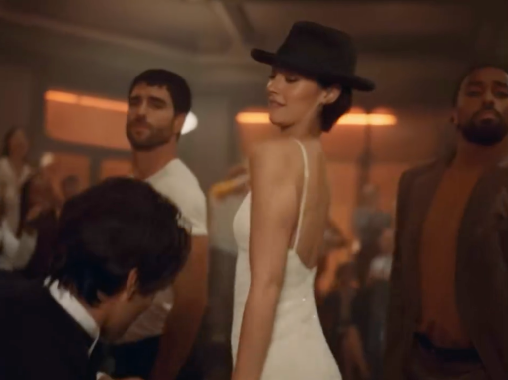 Gracie Abrams dancing in a white dress and black hat in the CHANEL COCO MADEMOISELLE CRUSH ABSOLU film