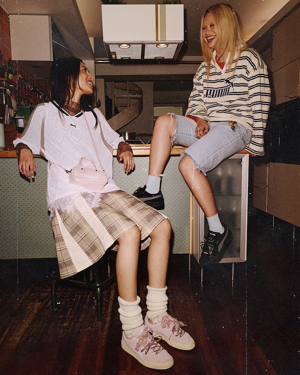 Two models in relaxed PUMA styling wearing Suede Bloom trainers in a domestic interior.