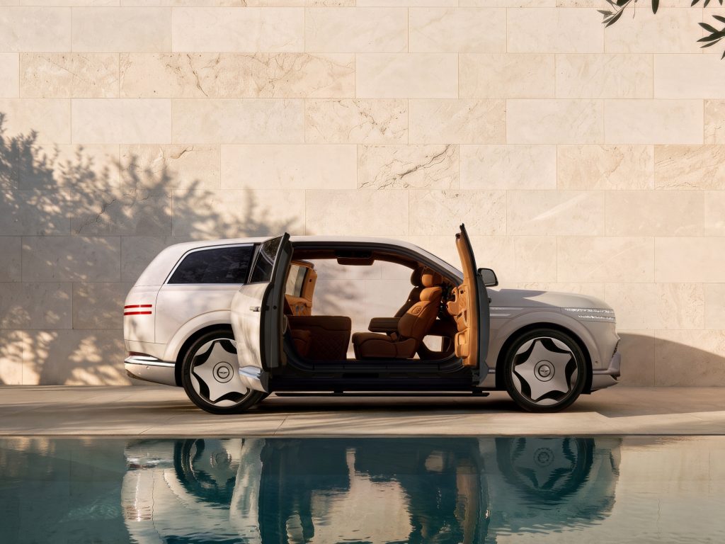 Silver Genesis GV90 in side profile with its pillarless coach-style doors open to reveal the tan cabin.
