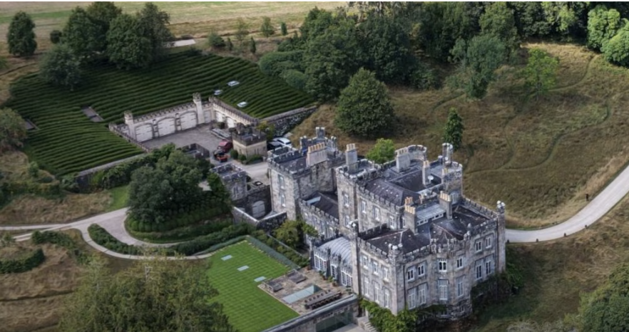 Wide aerial view of the historic Strancally Castle estate beneath dramatic Irish skies.