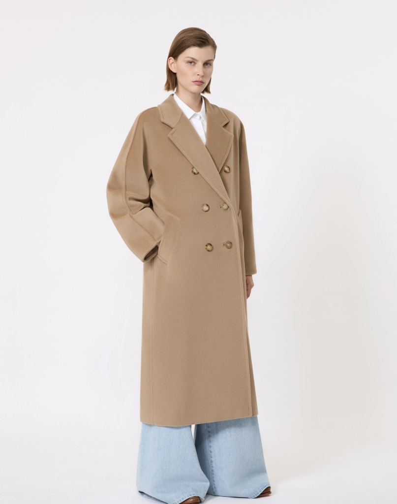 Model wearing a camel double-breasted Max Mara coat in a studio product image.