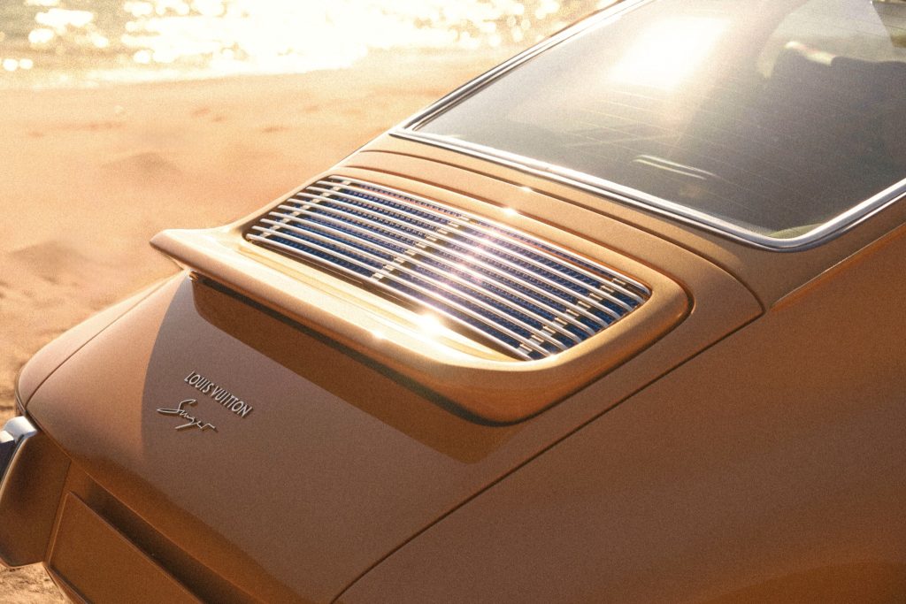 Rear detail of the saffron Porsche 911 Reimagined by Singer Classic showing the engine grille and Louis Vuitton Singer script.