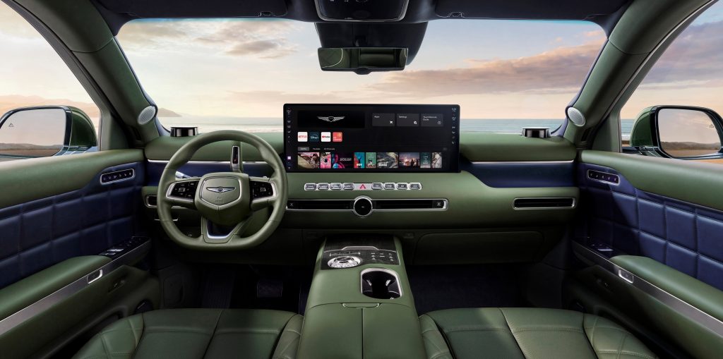 Genesis GV90 front cabin showing the steering wheel, dashboard display and green-and-blue interior trim.