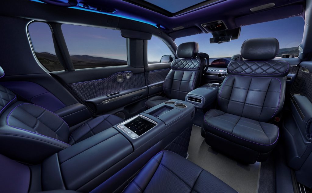 Dark blue executive lounge interior of the Genesis GV90 with two second-row seats and centre console.