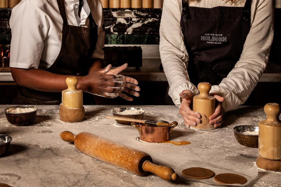 A guest shaping pastry beside a Pie Maker during a masterclass at The Pie Room, Rosewood London