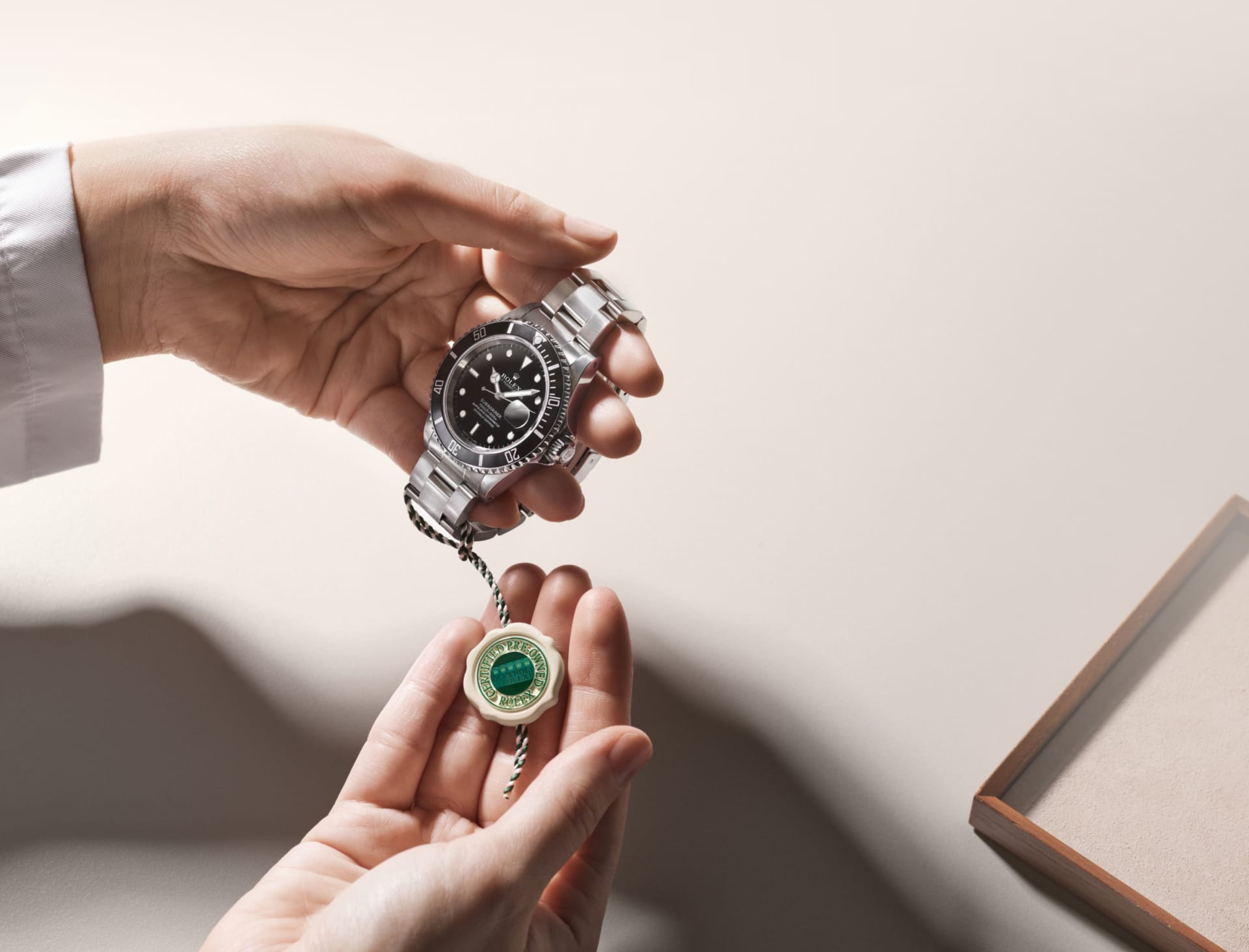 A Rolex Certified Pre-Owned watch presented with its distinctive green-and-white certification seal