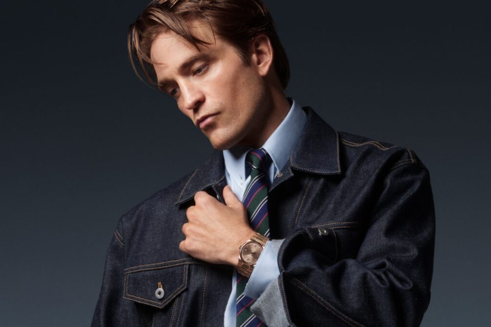 Robert Pattinson in dark denim and tailoring wearing the 18K pink-gold Jaeger-LeCoultre Master Control Chronometre Perpetual Calendar.