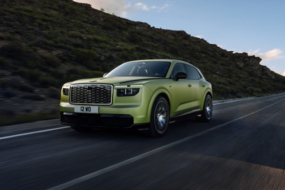 Green Bentley Torcal electric SUV seen from the front on a mountain road.