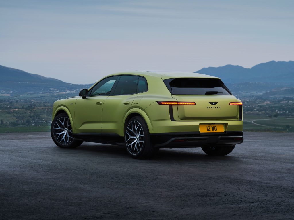 Rear three-quarter view of the green Bentley Torcal parked at a scenic overlook.