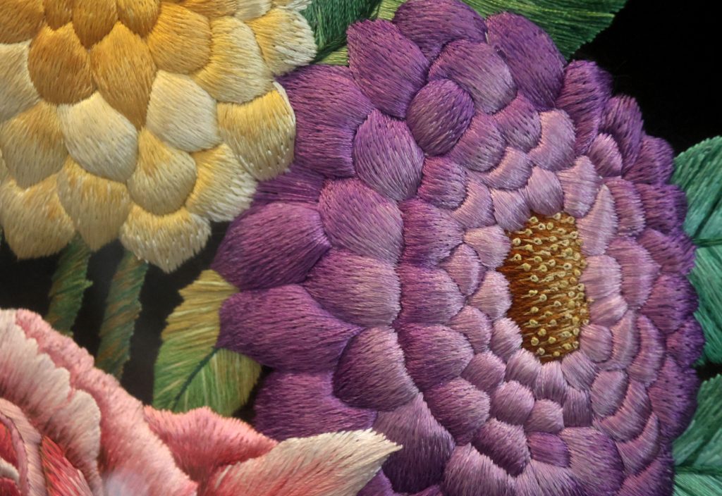 Raised silk flowers in The Vase, with layered purple and yellow petals.