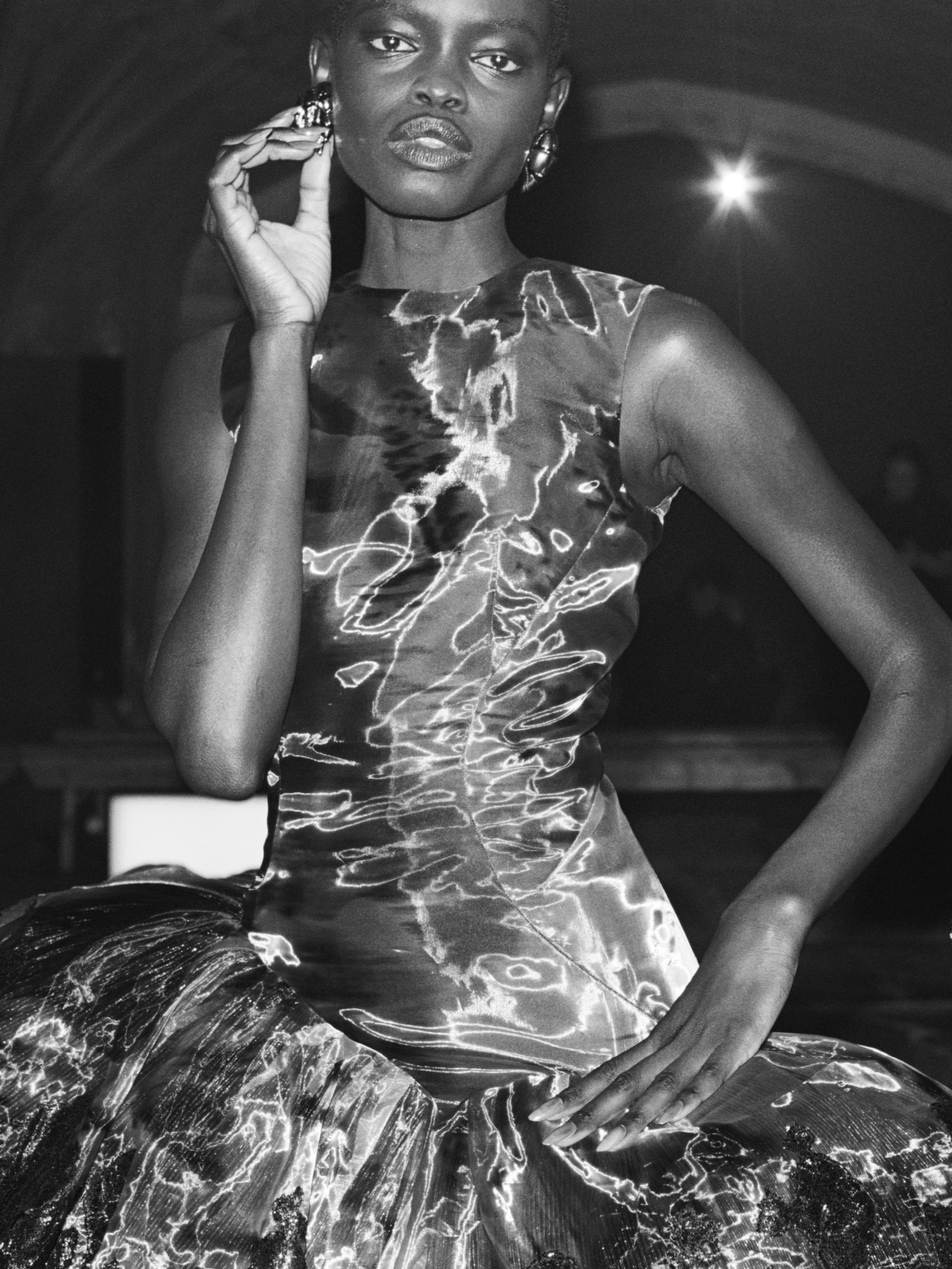 Close-up detail of acid floral motif on shimmering glass organza fabric with dark botanical print