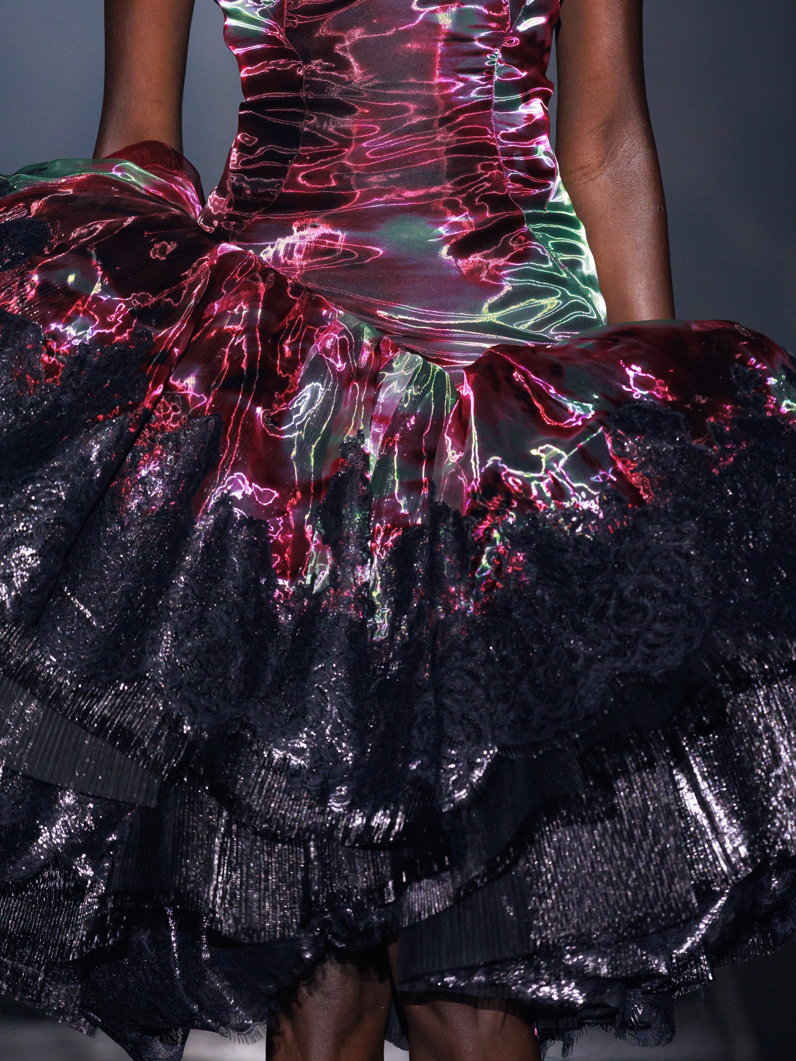 Model wearing glass organza gown with acid flowers and architectural lacquered lace detailing