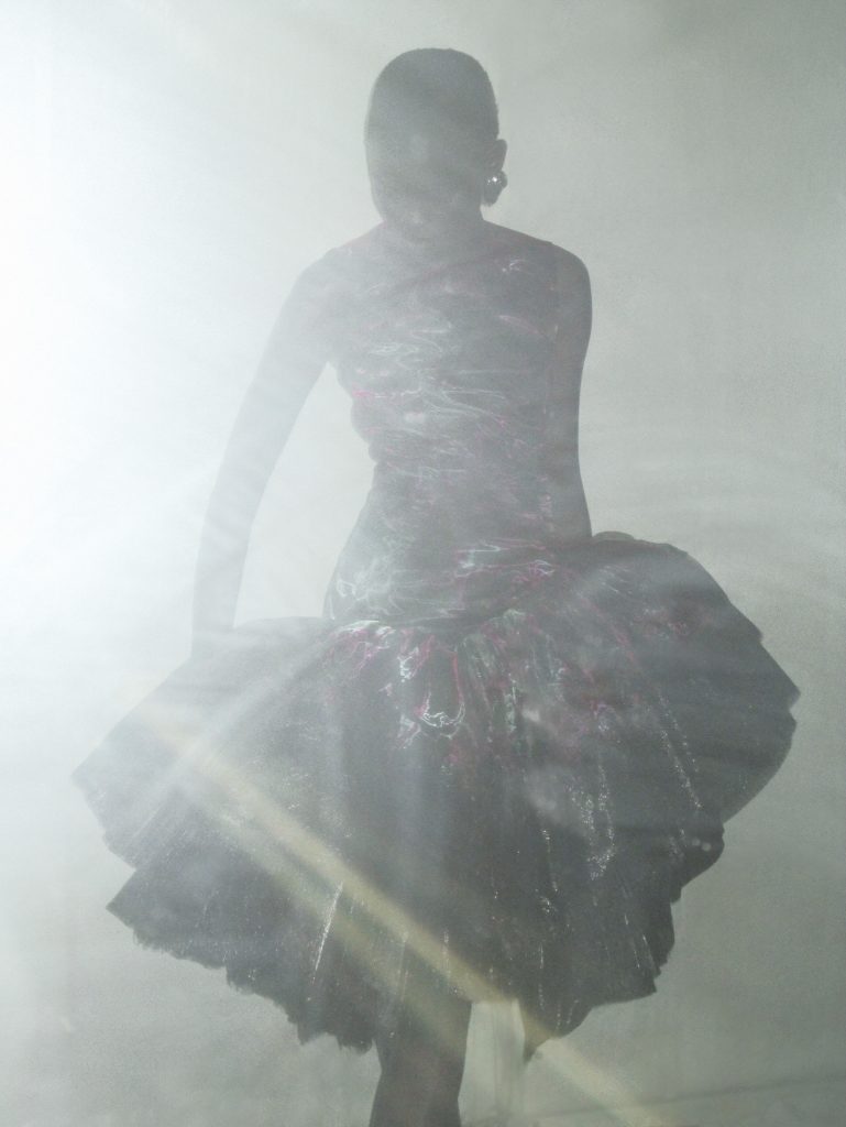 Side profile of glass organza silhouette with printed acid florals and lacquered lace accents