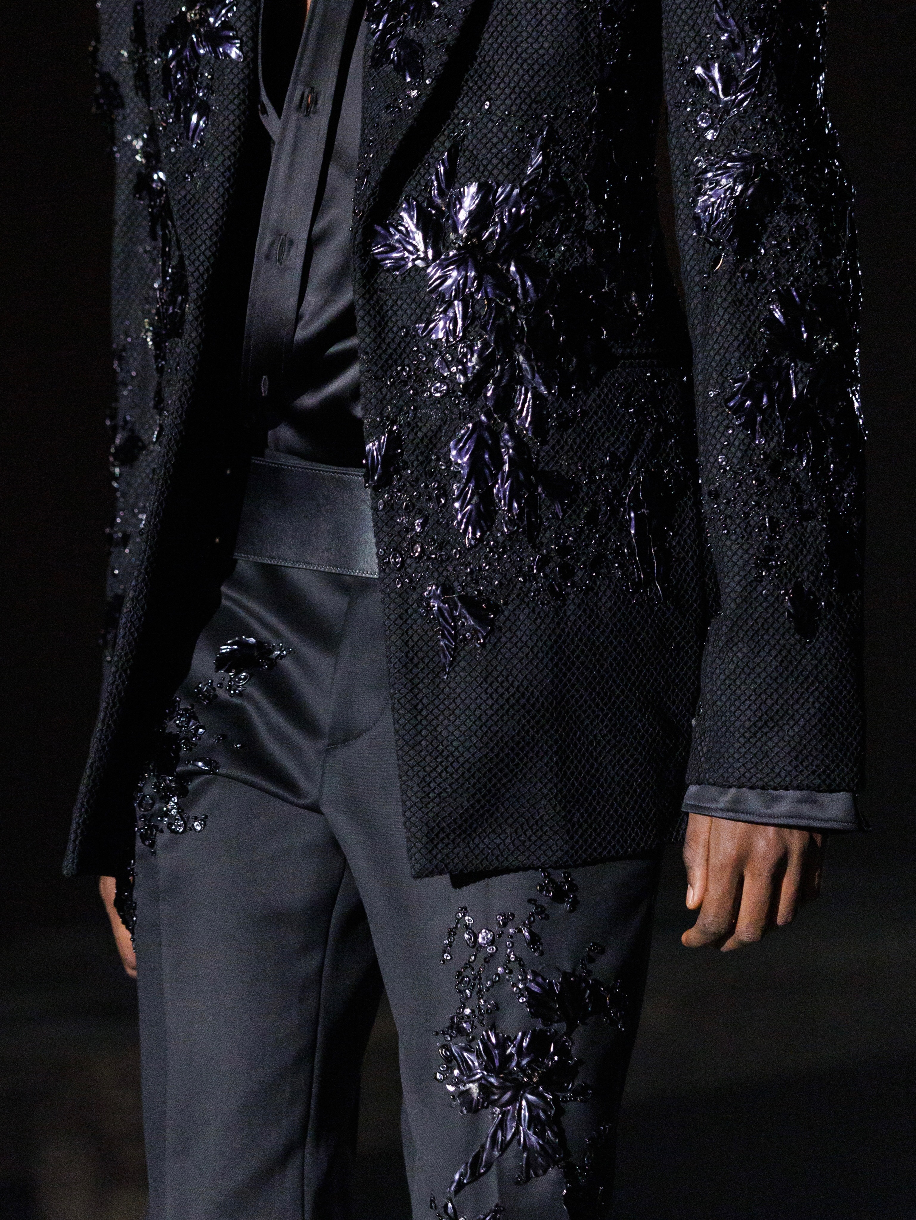 Side profile of model in evening garment with iridescent detailing