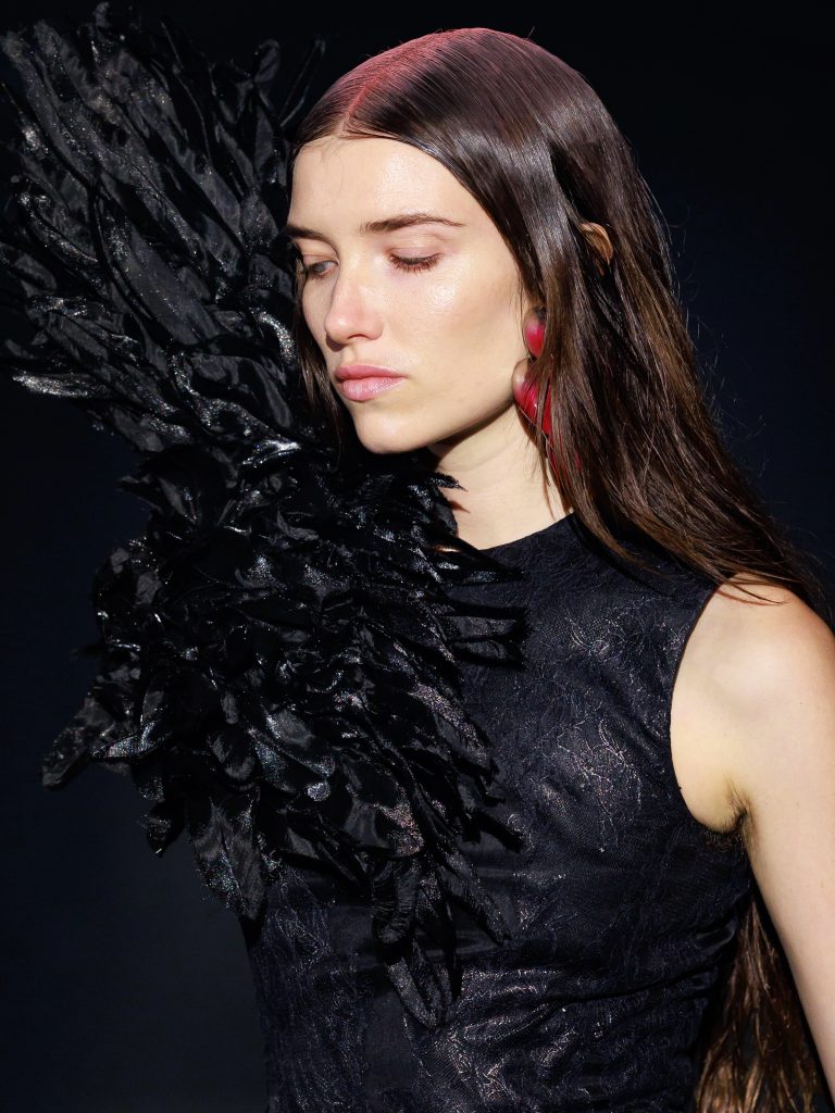 Full silhouette of feather-embellished black evening look