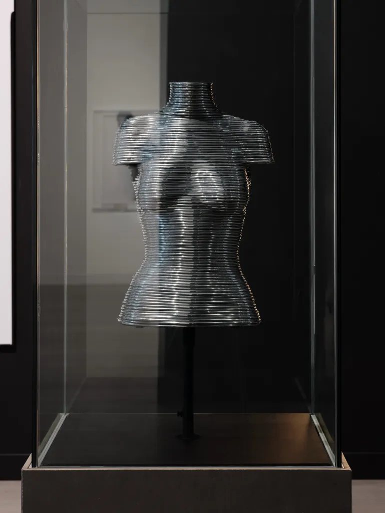 Full view of intricate armour garment by Sarah Harmarnee on exhibition display