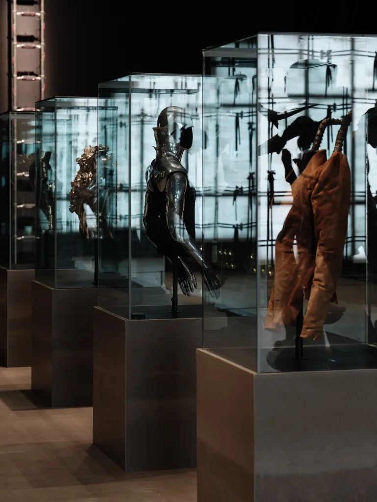 Installation view of Alexander McQueen pieces within The 90s: Art and Fashion exhibition