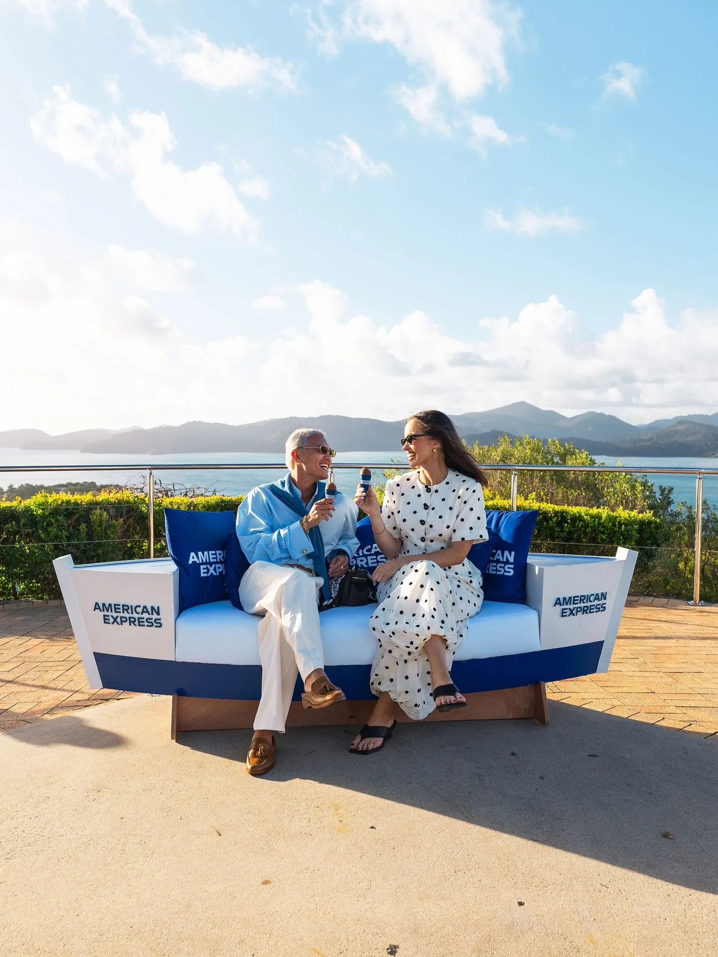 Sophisticated gathered guests enjoying cocktails during sunset aperitif service at the event