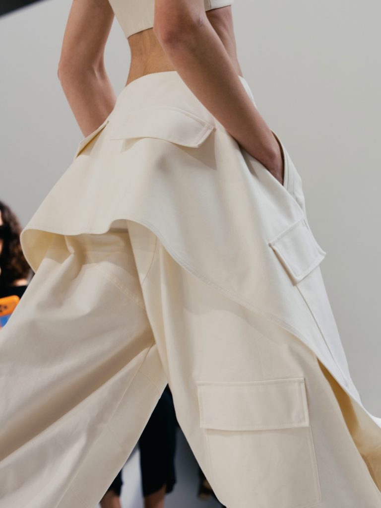 Full length silhouette in flowing coral fabric with minimalist construction
