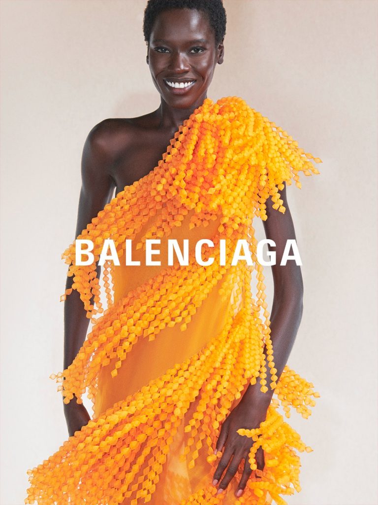 Model in terracotta-hued ensemble showcasing Balenciaga's architectural silhouettes