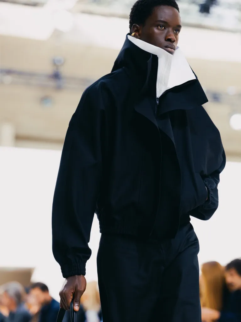 Close detail of layered textile combining rigid geometric shapes with organic draping