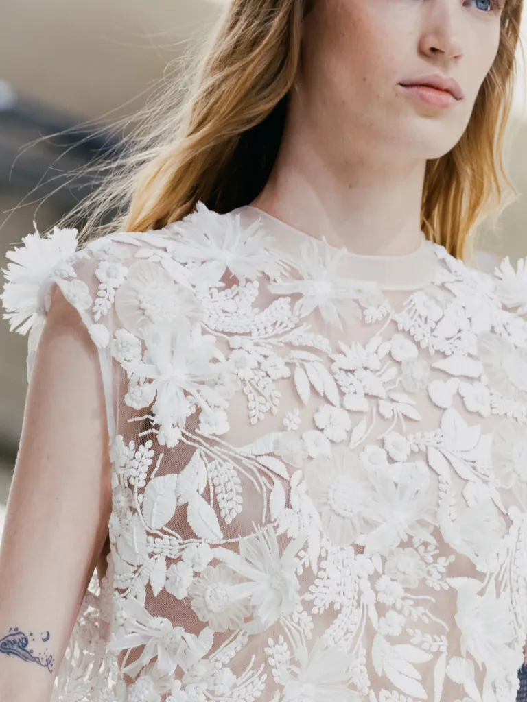 Model in cream and terracotta colour-blocked piece with sculptural sleeve construction