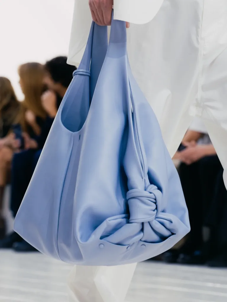 Close detail of structured coral tailored jacket with architectural seaming