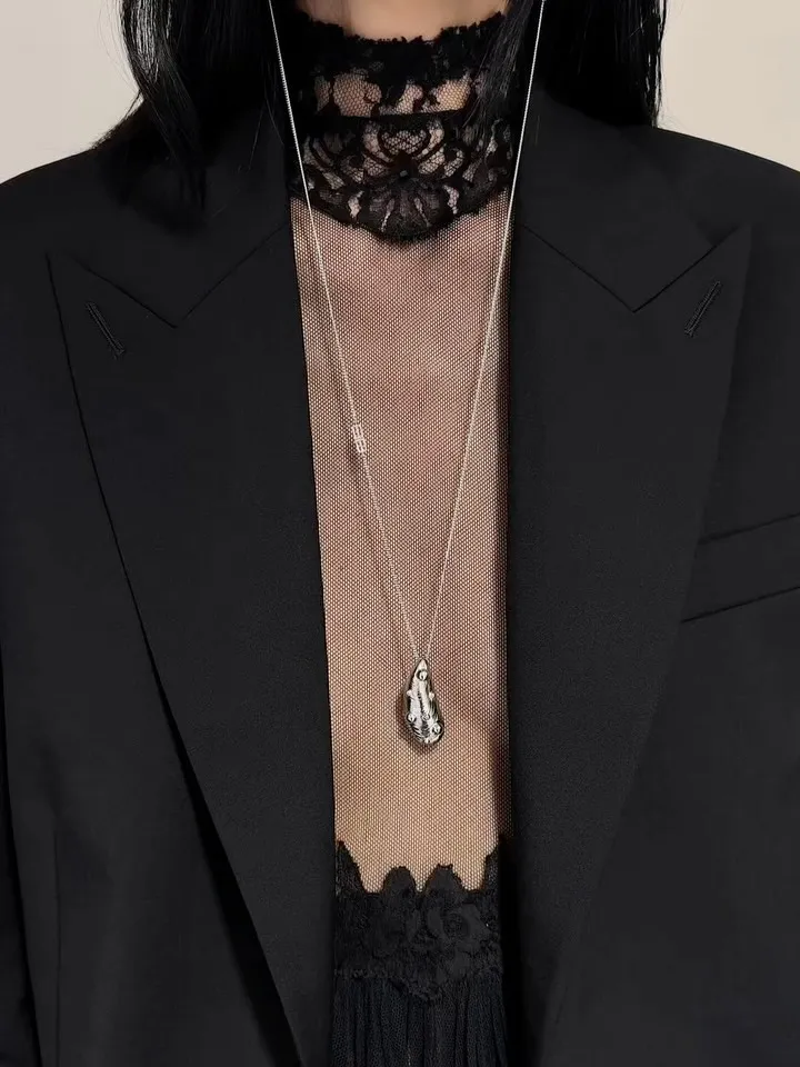 Architectural detail of shoulder construction and layered silhouettes in warm neutral tones