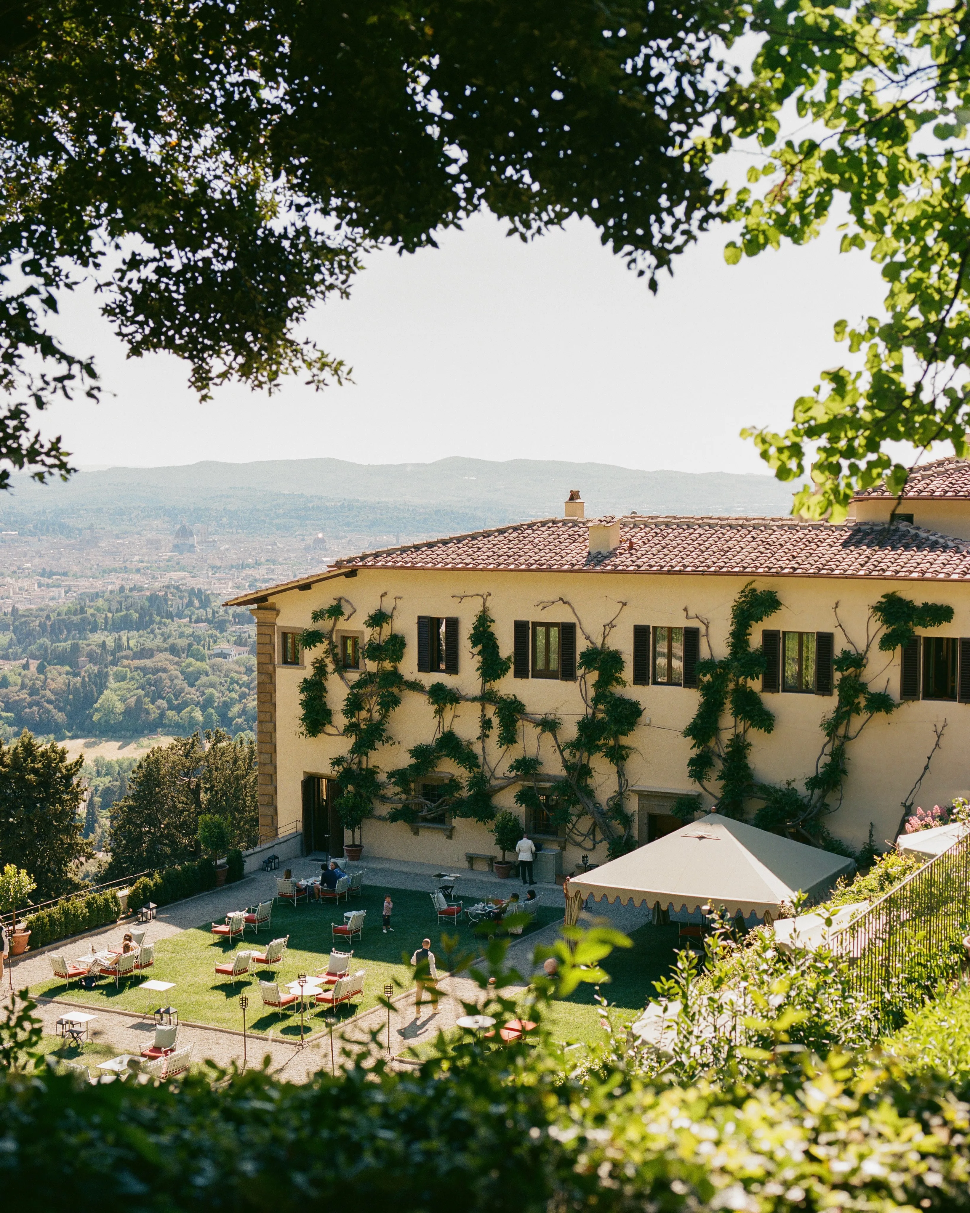 Cascading terraced gardens at Belmond Villa San Michele with flowering vines and classical stone sculptures overlooking Florence