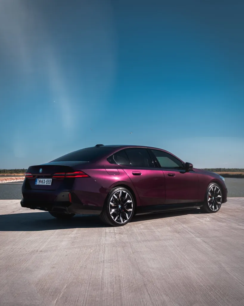 Rear quarter view displaying the 550e xDrive's cohesive design language and muscular rear haunches against scenic backdrop