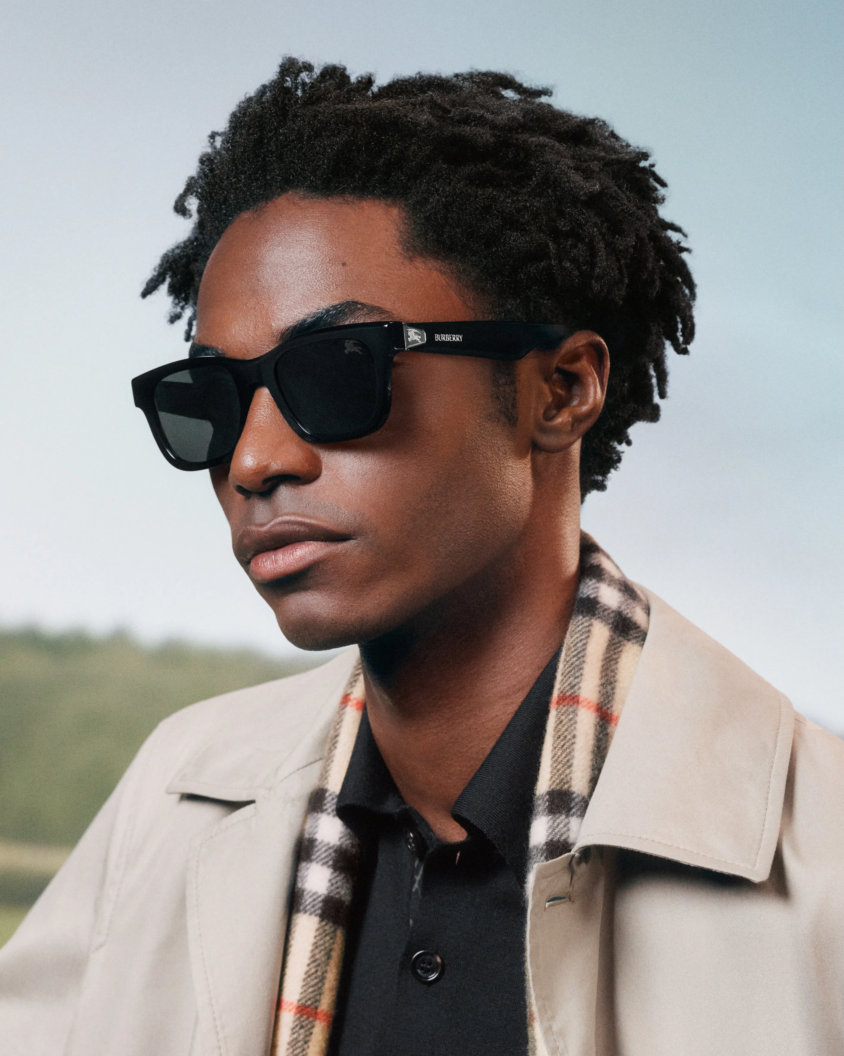 Model wearing the architectural sunglasses while gazing towards pastoral landscape