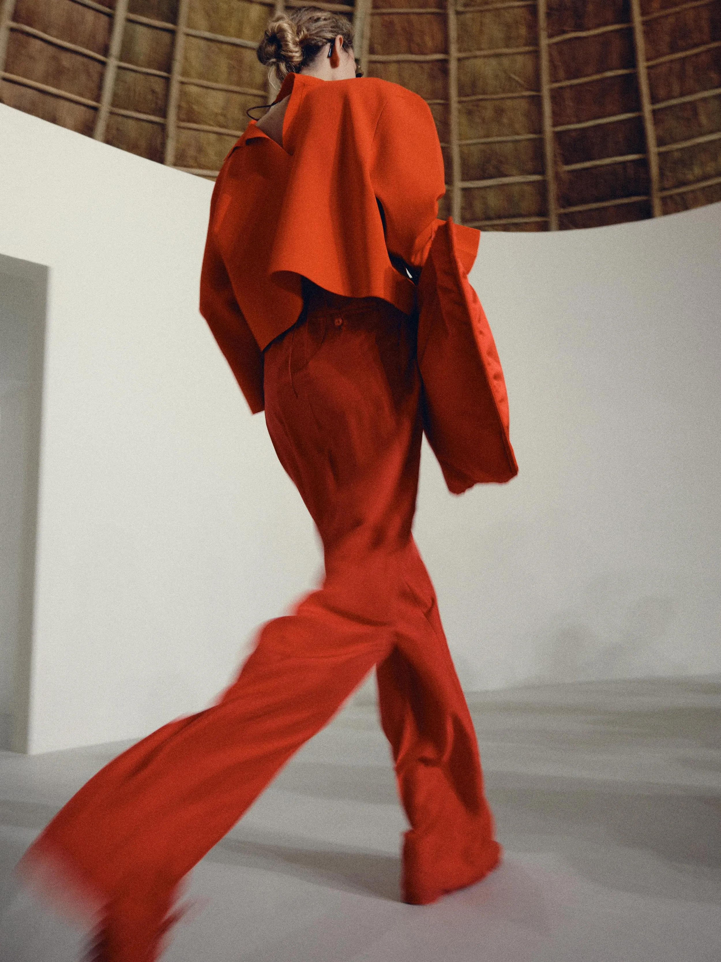 Full length view of model in soft taupe silhouette with architectural draping