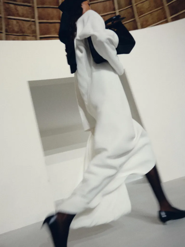 Model in layered neutrals showcasing the collection's sophisticated proportion play