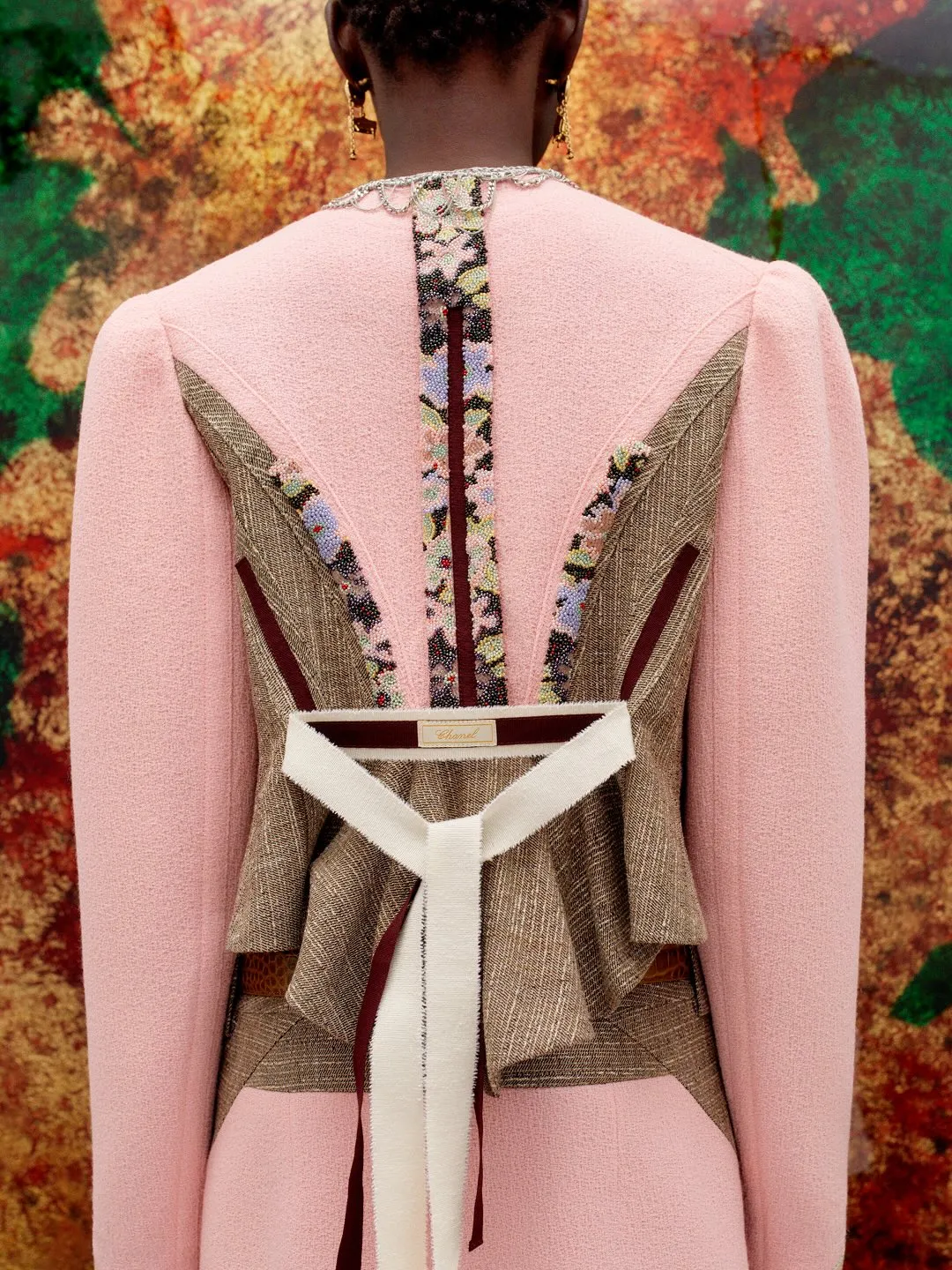 Model wearing a tailored cream silk blend jacket with subtle texture detailing