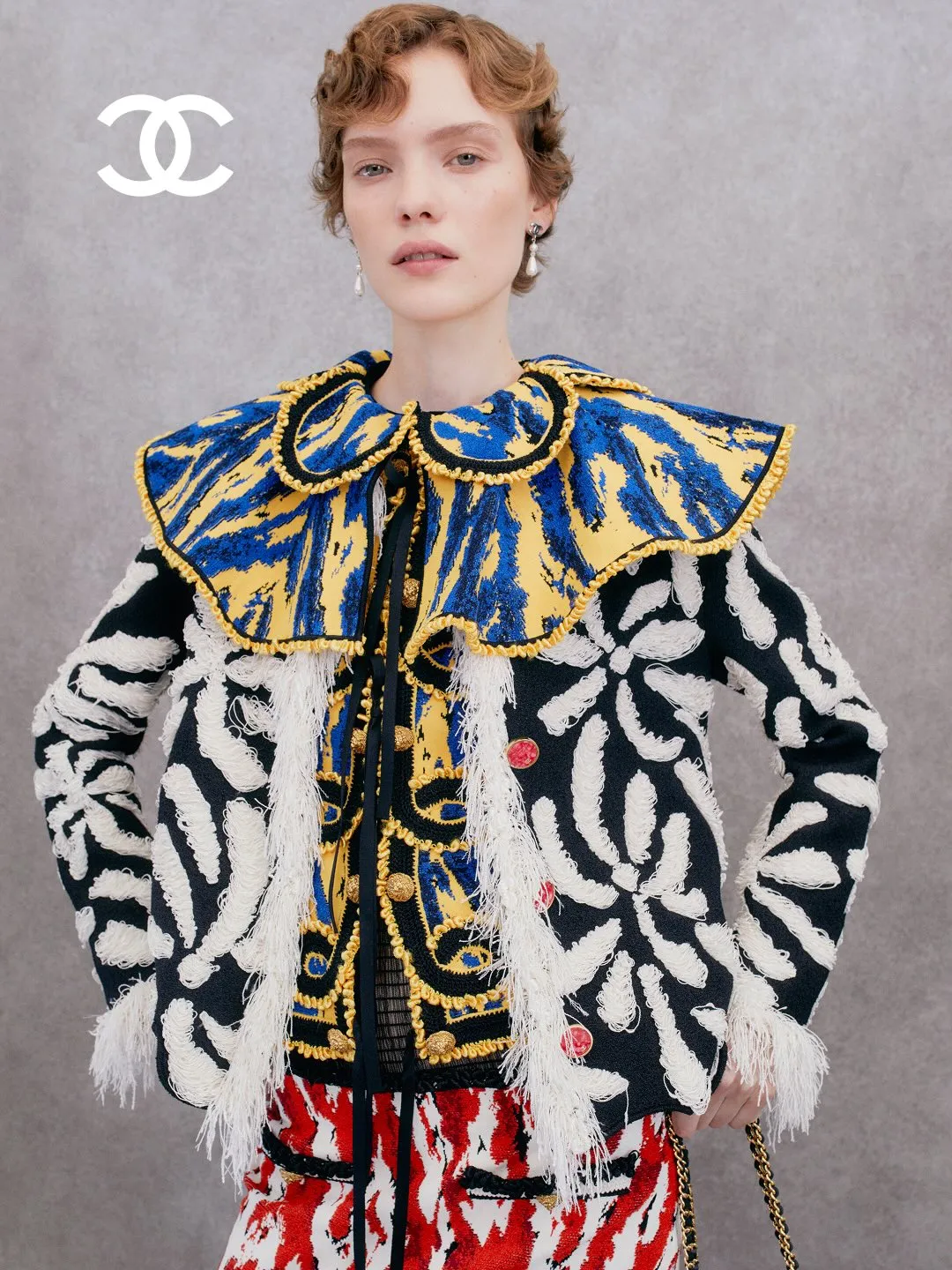 Model wearing structured cream-coloured jacket with quilted detailing and pearl embellishments
