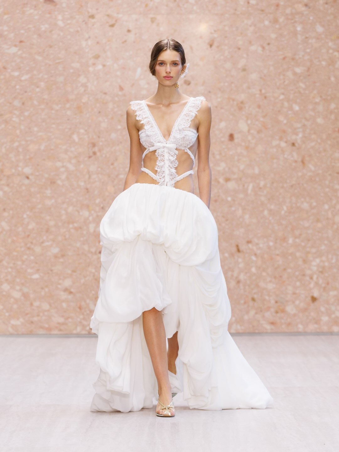 Model wearing flowing cream silk gown with layered transparent fabric detail