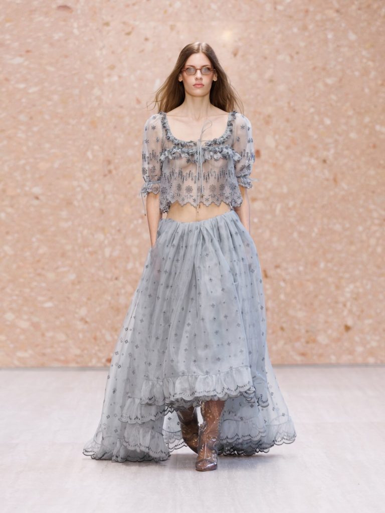 Detailed view of intricate pleating on a champagne-toned shift dress