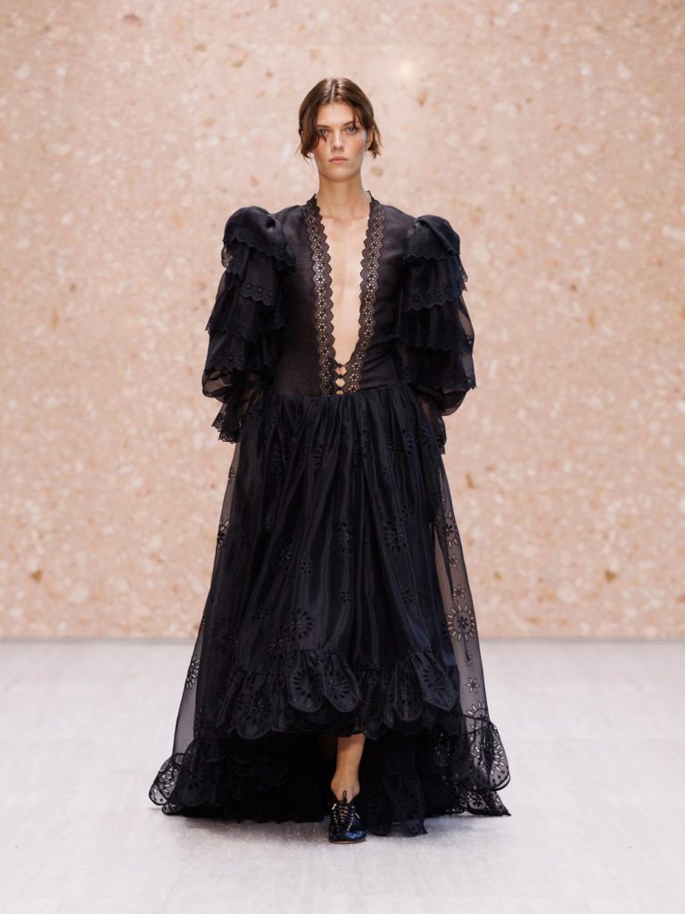 Model in sheer layered dress with strategic transparency and refined draping