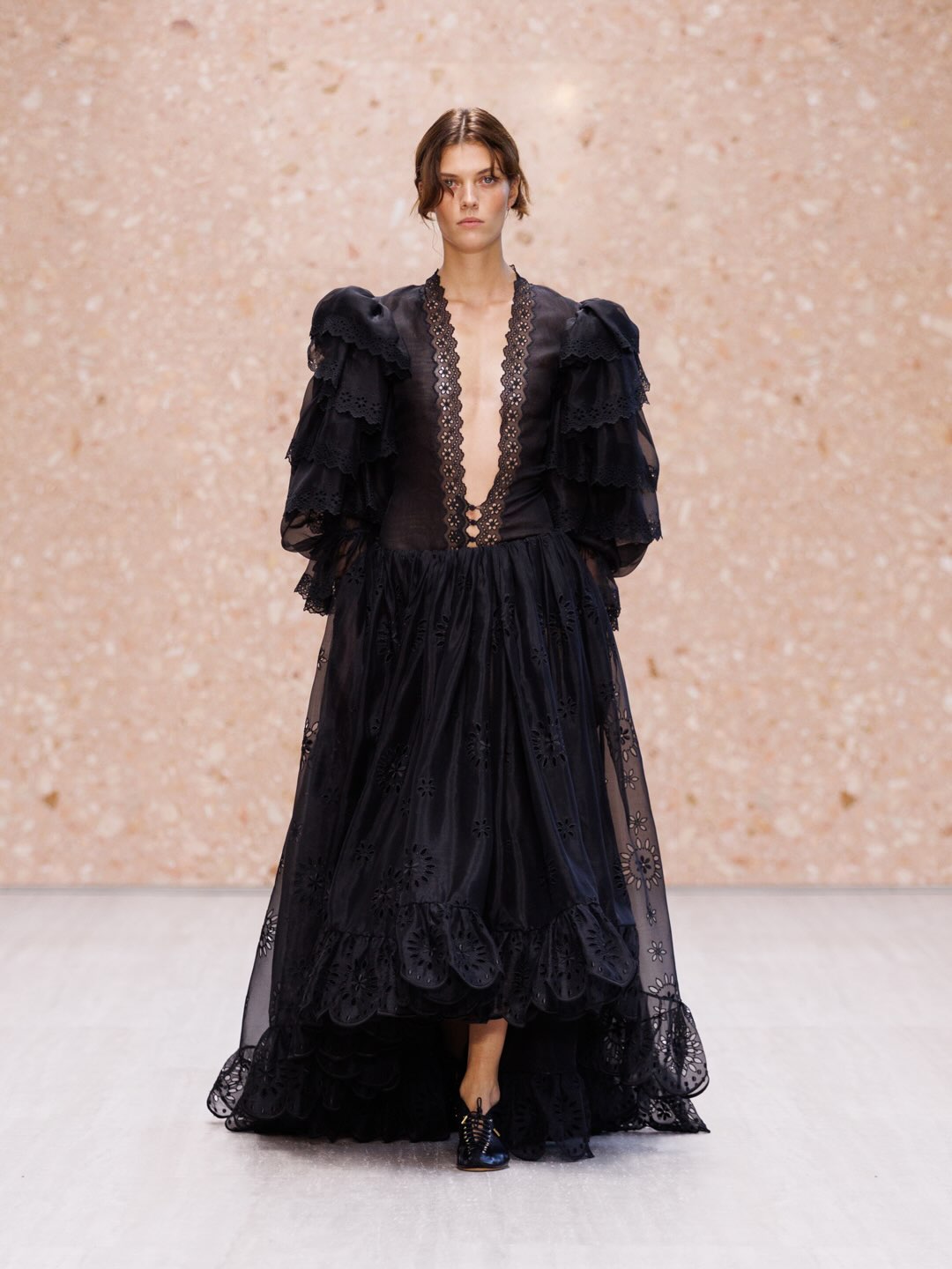 Model in sheer layered dress with strategic transparency and refined draping