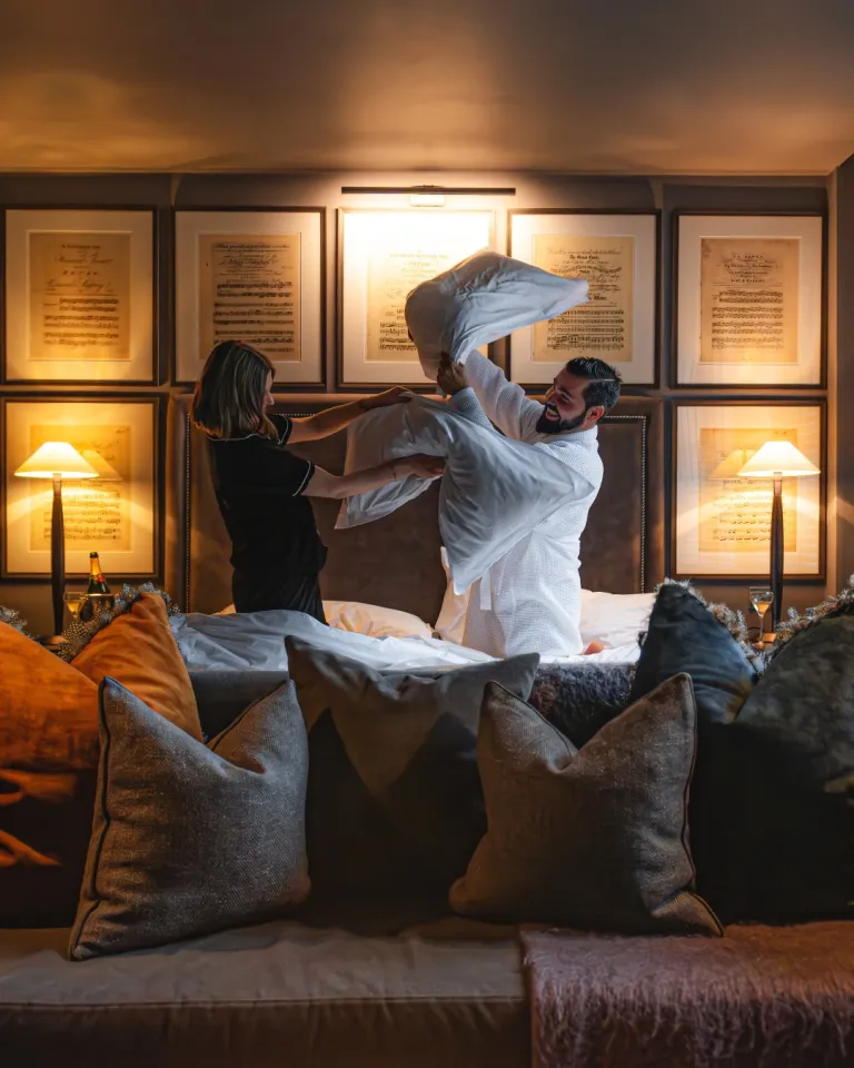 Luxuriously appointed Dakota hotel bedroom with soft, layered bedding and warm autumn morning light