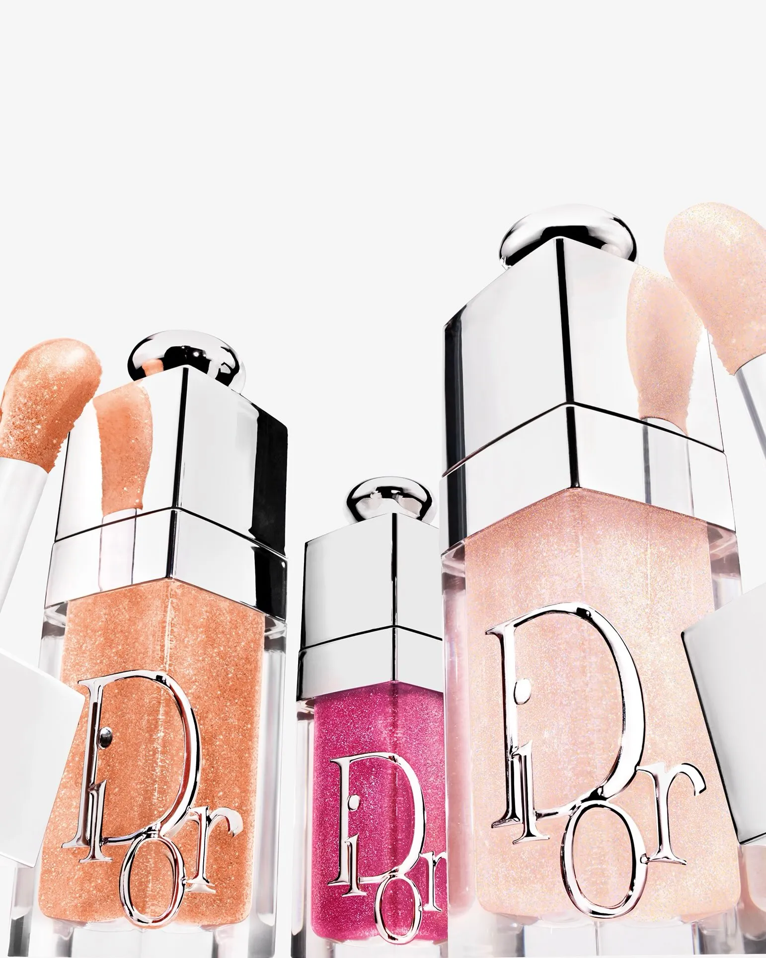 Dior Addict Lip Glow and Dior Addict Lip Glow Oil limited edition tubes arranged to showcase their luminous finishes and festive packaging