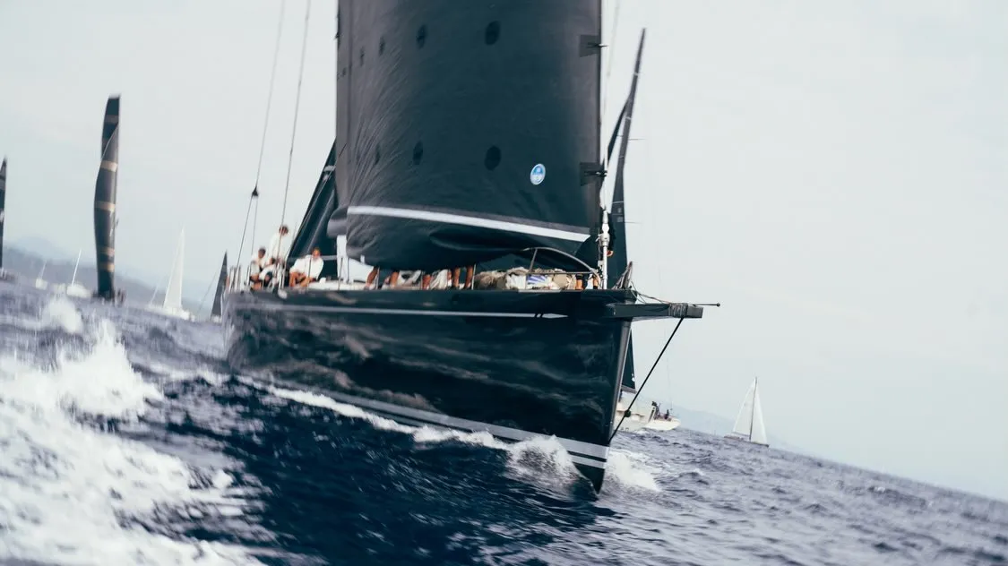 Maxi class racing yachts with billowing white sails competing in the waters off Saint-Tropez
