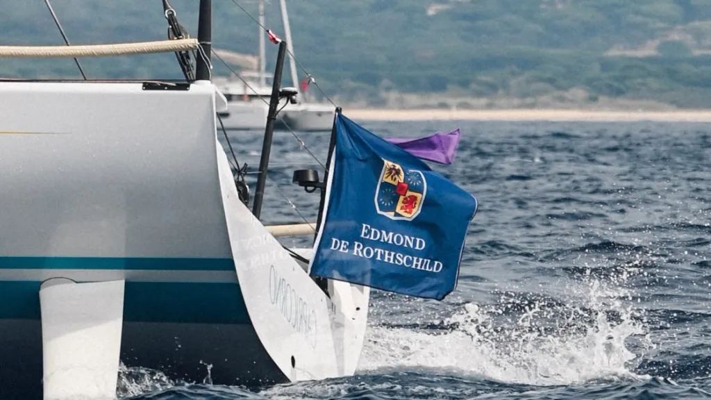 Crew members executing precise manoeuvres aboard a Maxi racing yacht during competitive sailing