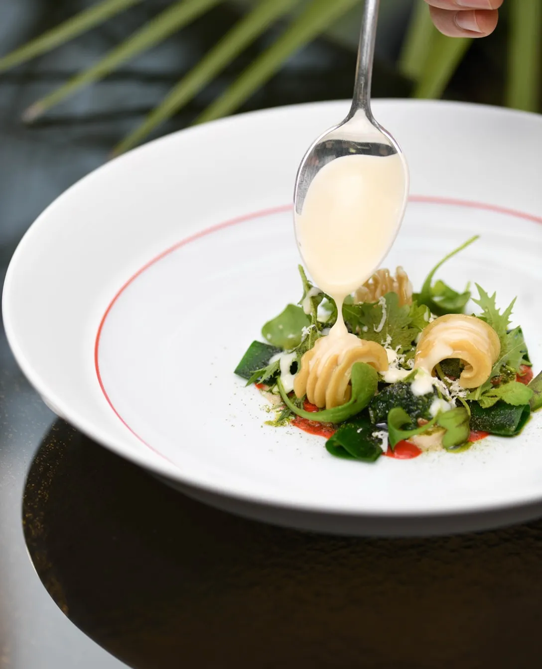 Plated grey rabbit with winter pesto and smoked radiatori pasta, garnished with bay leaf at Enrico Bartolini al Mudec