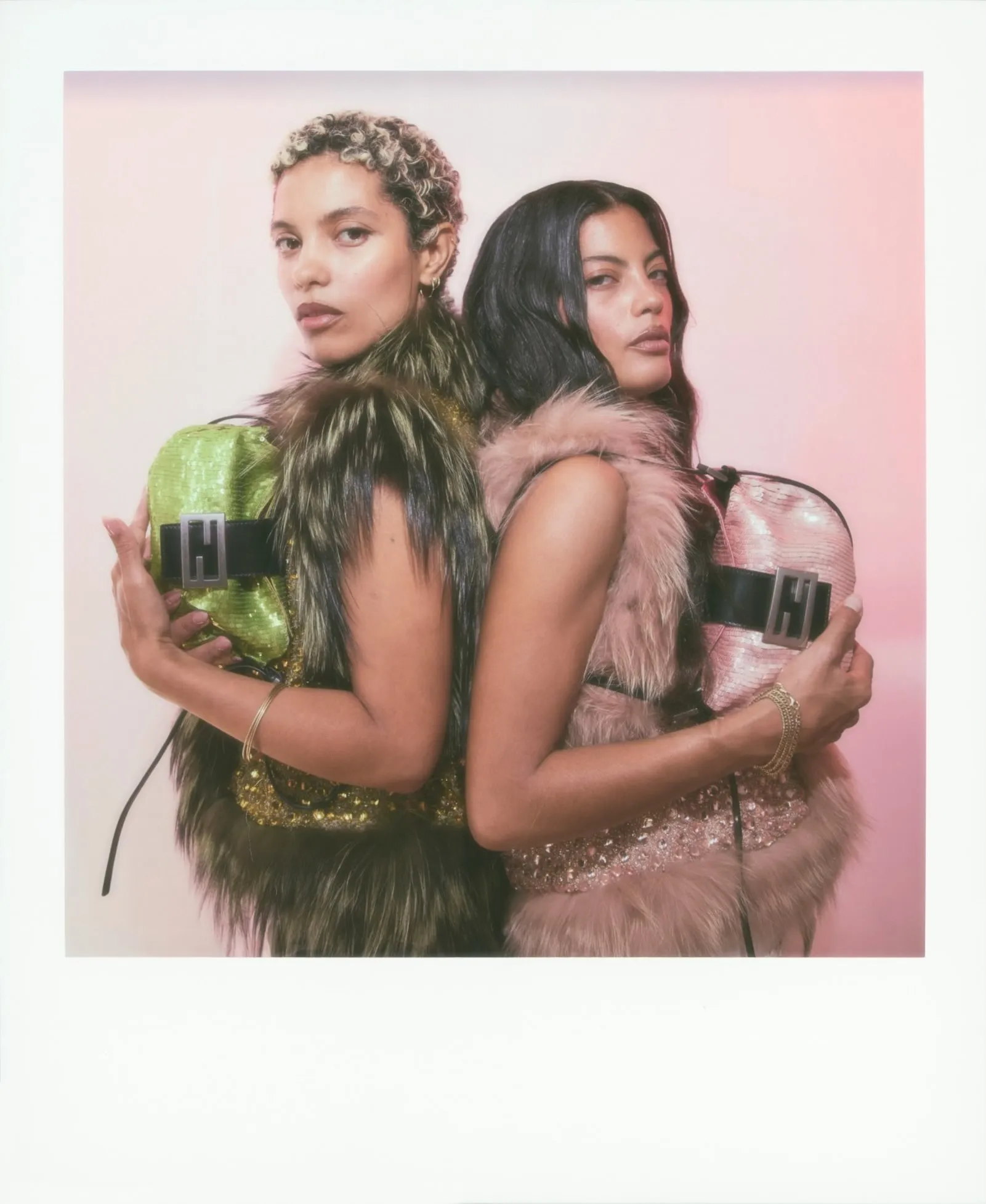 Ibeyi members Lisa-Kaindé and Naomi Diaz holding Fendi's sequined Croissant bags in iridescent iterations, photographed by Maripol during the Spring/Summer 2027 show