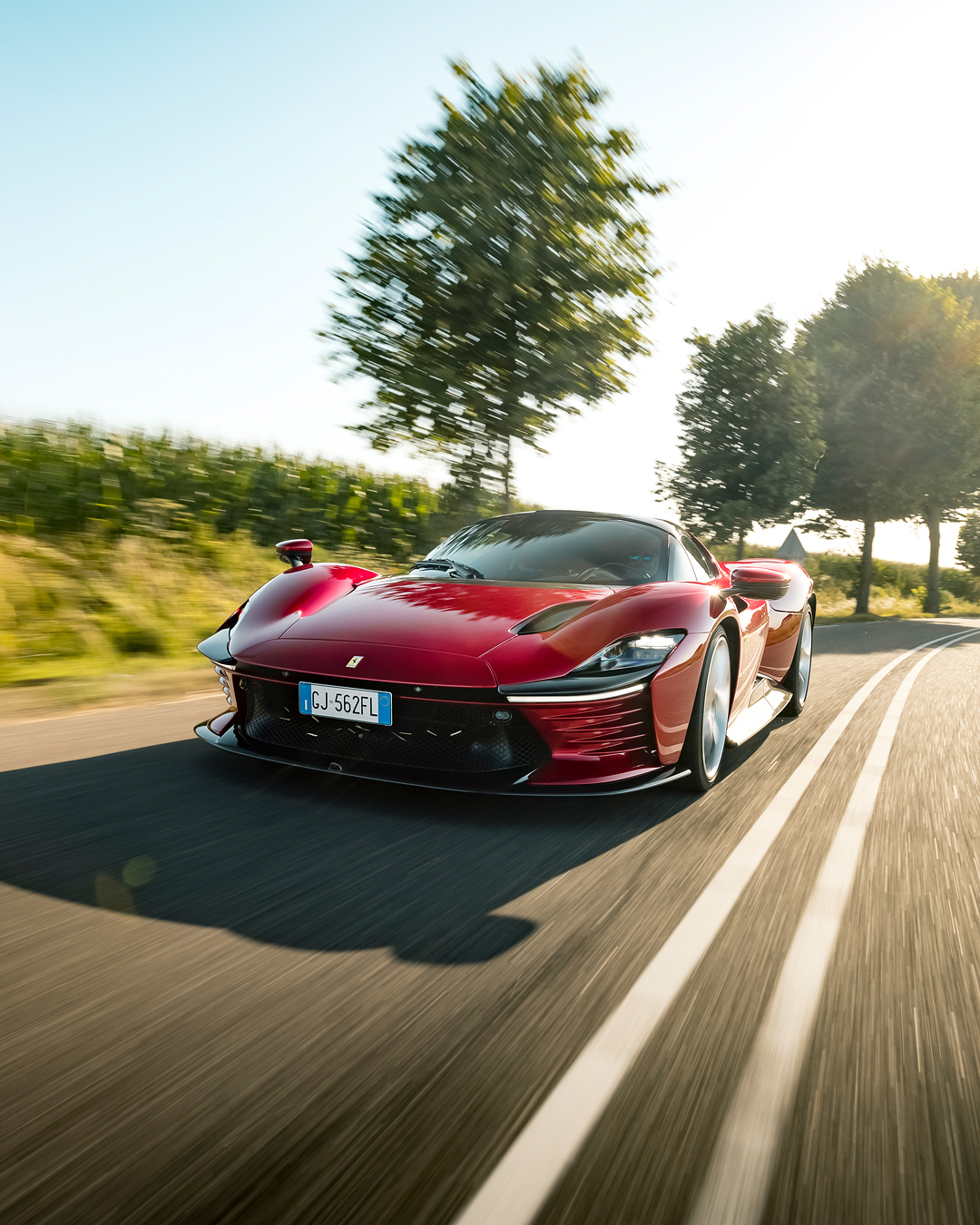 The Ferrari Daytona SP3 photographed in dynamic motion, capturing its sculpted profile and iconic red finish